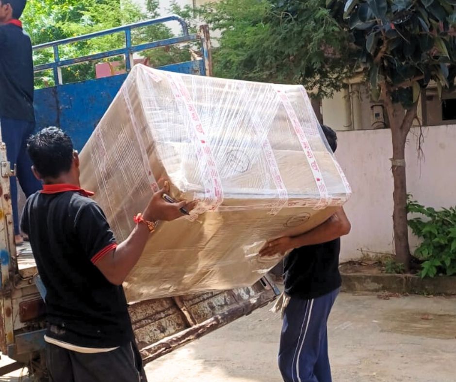 professional packers movers team loading packed table in truck