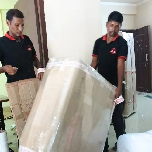 Professional Om Sai packers and movers in Barh carefully packing and moving furniture with protective wrapping during a home relocation.
